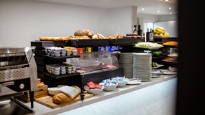Un bufé de desayuno con diversas opciones de comida y una máquina de café.