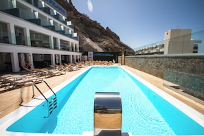 A swimming pool with sun loungers and a lifebuoy, surrounded by a building with a sign reading 'NACHOSOL ATLANTIC HOTEL'. - IG Nachosol Atlantic & Yaizasol by Servatur (Mogan)