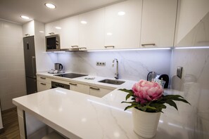 A modern kitchen with white cabinetry, a marble countertop, a built-in microwave, a coffee maker, and a potted plant. - IG Nachosol Atlantic & Yaizasol by Servatur (Mogan)