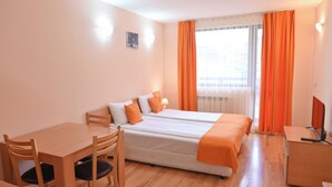A hotel room with two beds, a desk, and a chair. - Orbilux (Bansko)