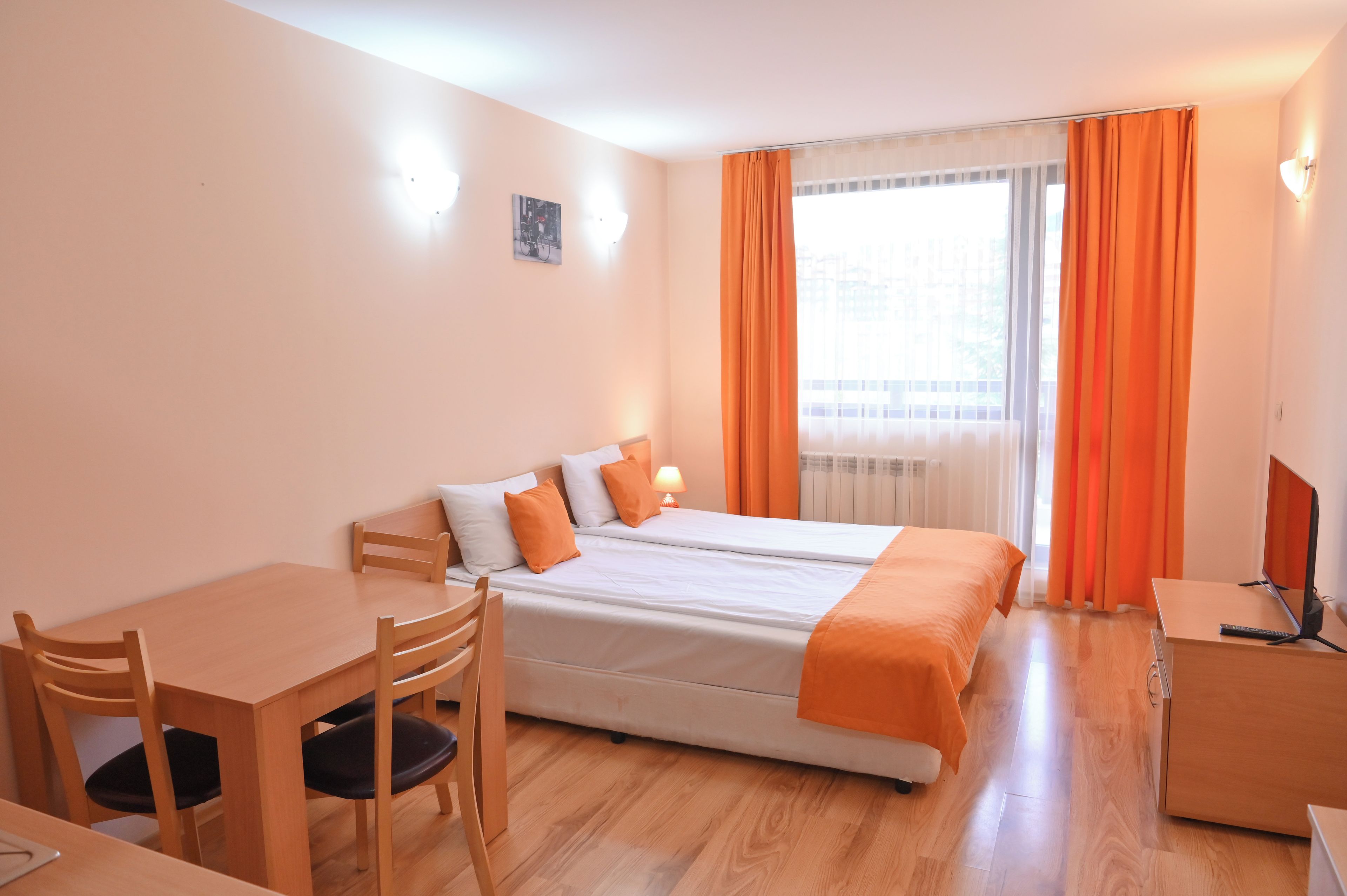 A hotel room with two beds, a desk, and a chair.