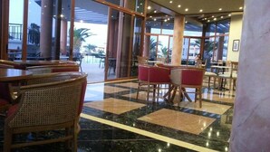 A spacious lobby with a checkered floor, large windows, and a view of the outdoor area.