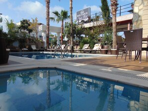 Piscine extérieure, parasols de plage, chaises longues