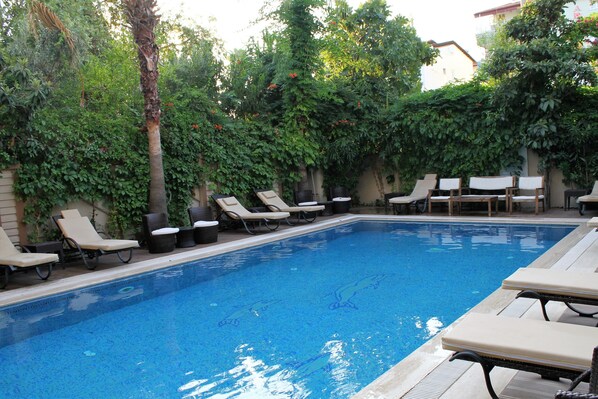 Piscine extérieure, parasols de plage, chaises longues