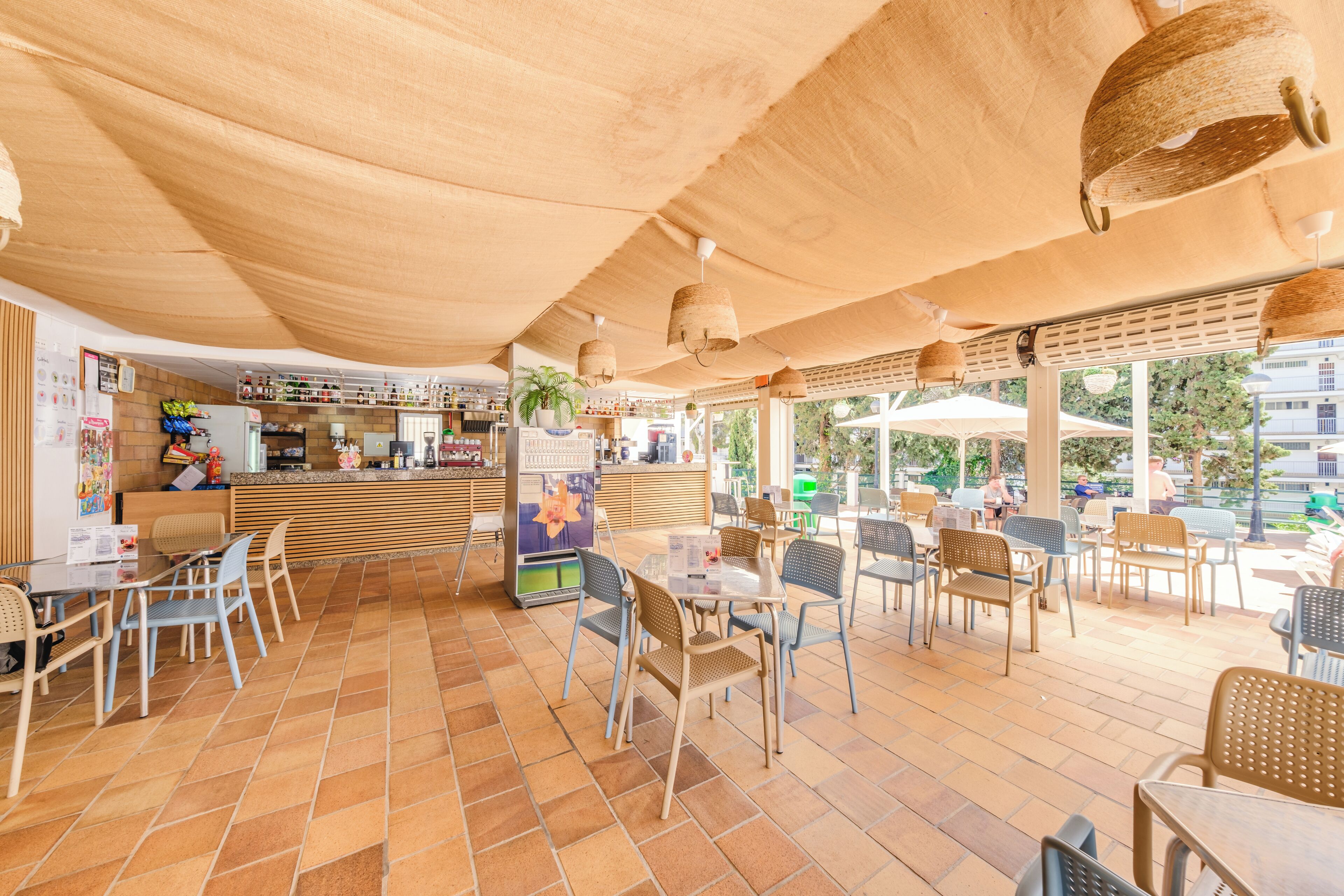 A cafe with outdoor seating, a counter, and a view of the street.