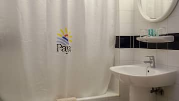 A bathroom with a white sink, a mirror, and a shower curtain with a logo.