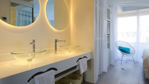 A modern bathroom with a glass bowl sink, two mirrors, and a white vanity.