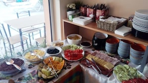 A buffet with various food items, including fruits, cheeses, and meats, arranged on a table with a view of the outdoors. - Darius (Sunny Beach)