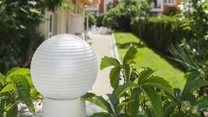A multi-story residential building with balconies, surrounded by greenery and a pathway. - Darius (Sunny Beach)