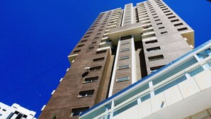 Een hoog gebouw met meerdere verdiepingen, grote ramen en een modern architectonisch ontwerp.