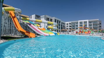 A swimming pool with multiple water slides and lounge chairs.