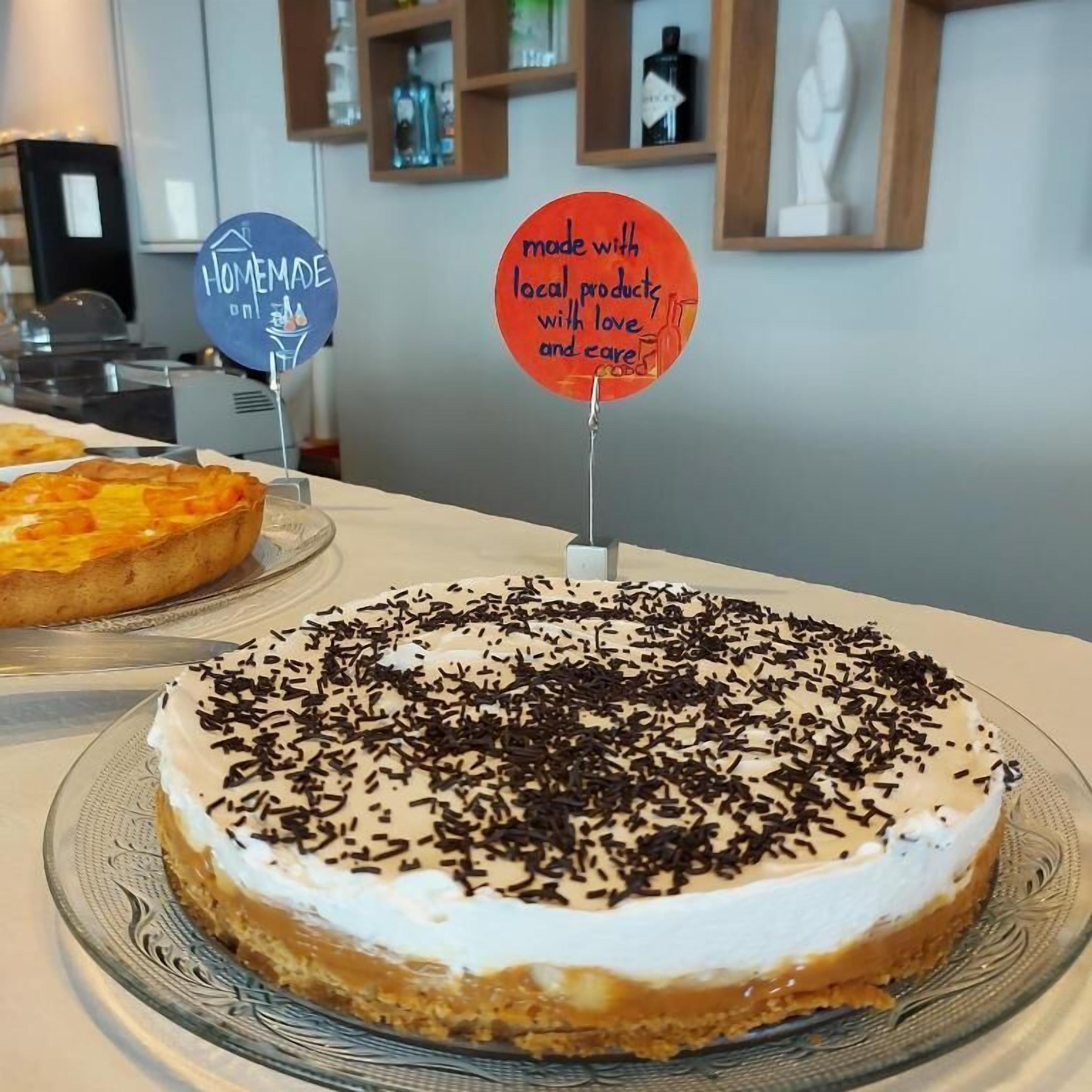 A dessert display with a cake topped with white frosting and chocolate sprinkles.
