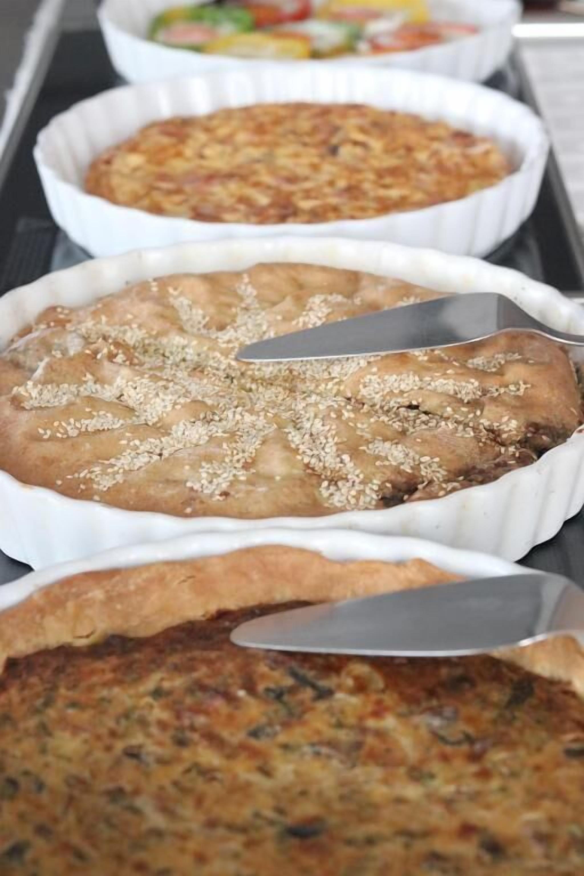Un plateau de pâtisseries, dont une tarte recouverte de graines de sésame.
