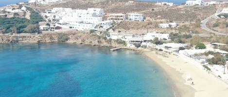 Un pueblo costero con edificios blancos, una playa y aguas azules cristalinas.