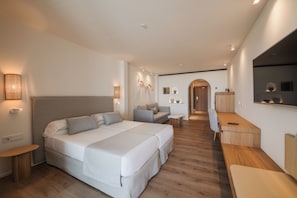 A modern hotel room with a large bed, a desk, and a sofa. - Blau Park (Sant Antoni de Portmany)