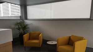 A modern office space with two yellow armchairs and a small round table. - Puerto Principe Apartments (PUERTO RICO)