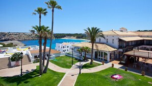 A coastal property with a patio, palm trees, and a view of the sea. - Aparthotel Seth Isla Paraiso (Mercadal)