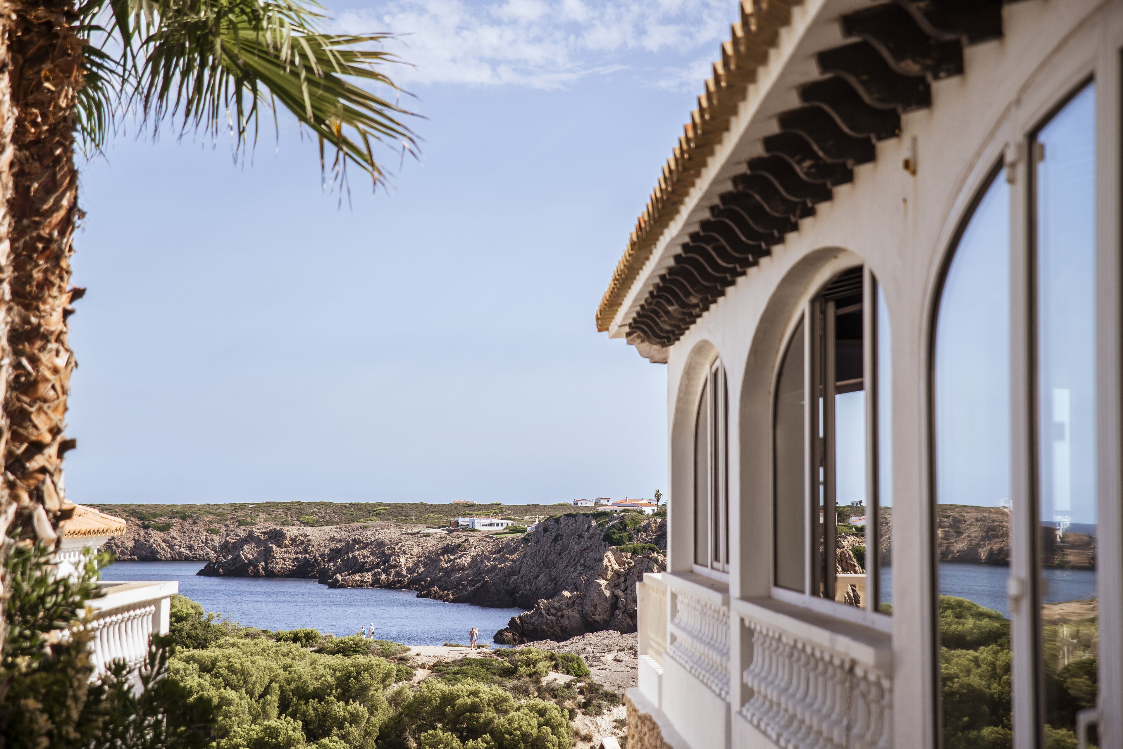 Un edificio sul lungomare con vista sul mare e sulle scogliere rocciose.