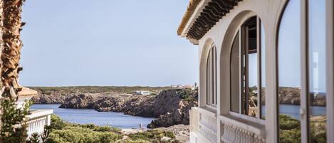 Un edificio sul lungomare con vista sul mare e sulle scogliere rocciose.