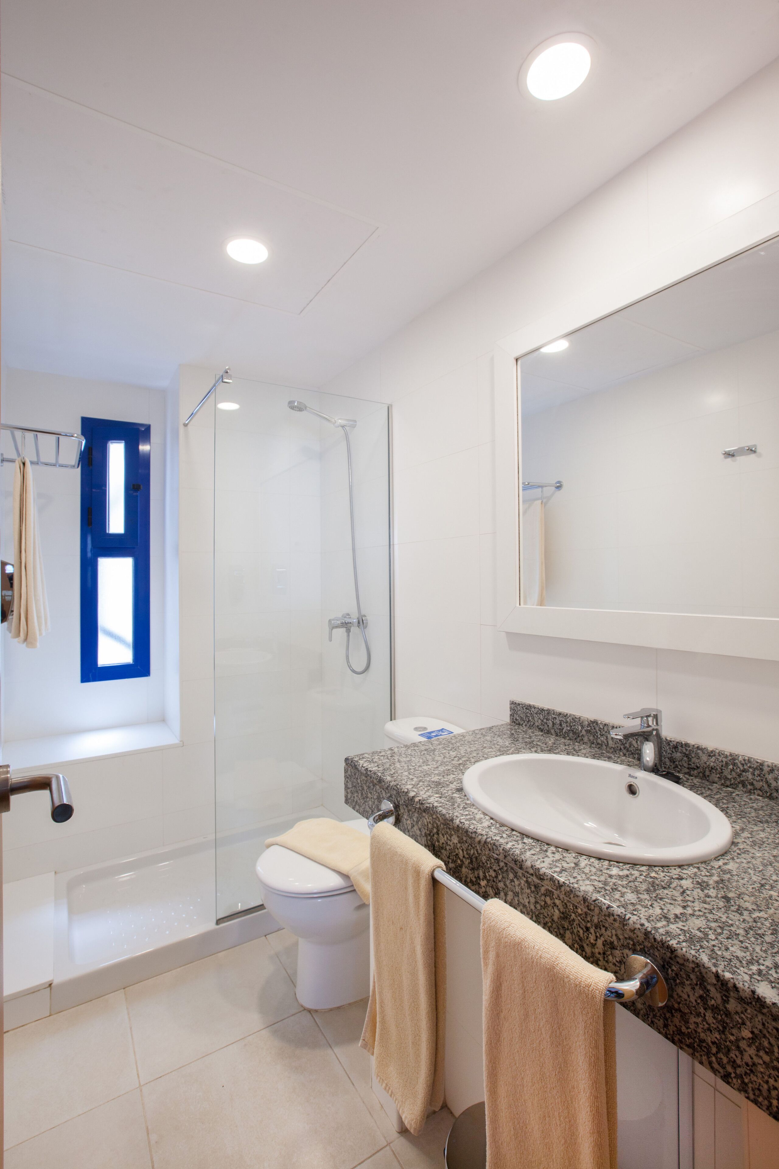 Un baño moderno con ducha, inodoro y lavamanos.