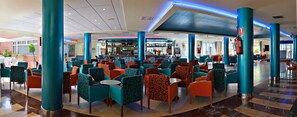 A spacious indoor area with multiple seating arrangements, a bar area, and a fire extinguisher mounted on a pillar. - Tropic Relax (Finestrat)