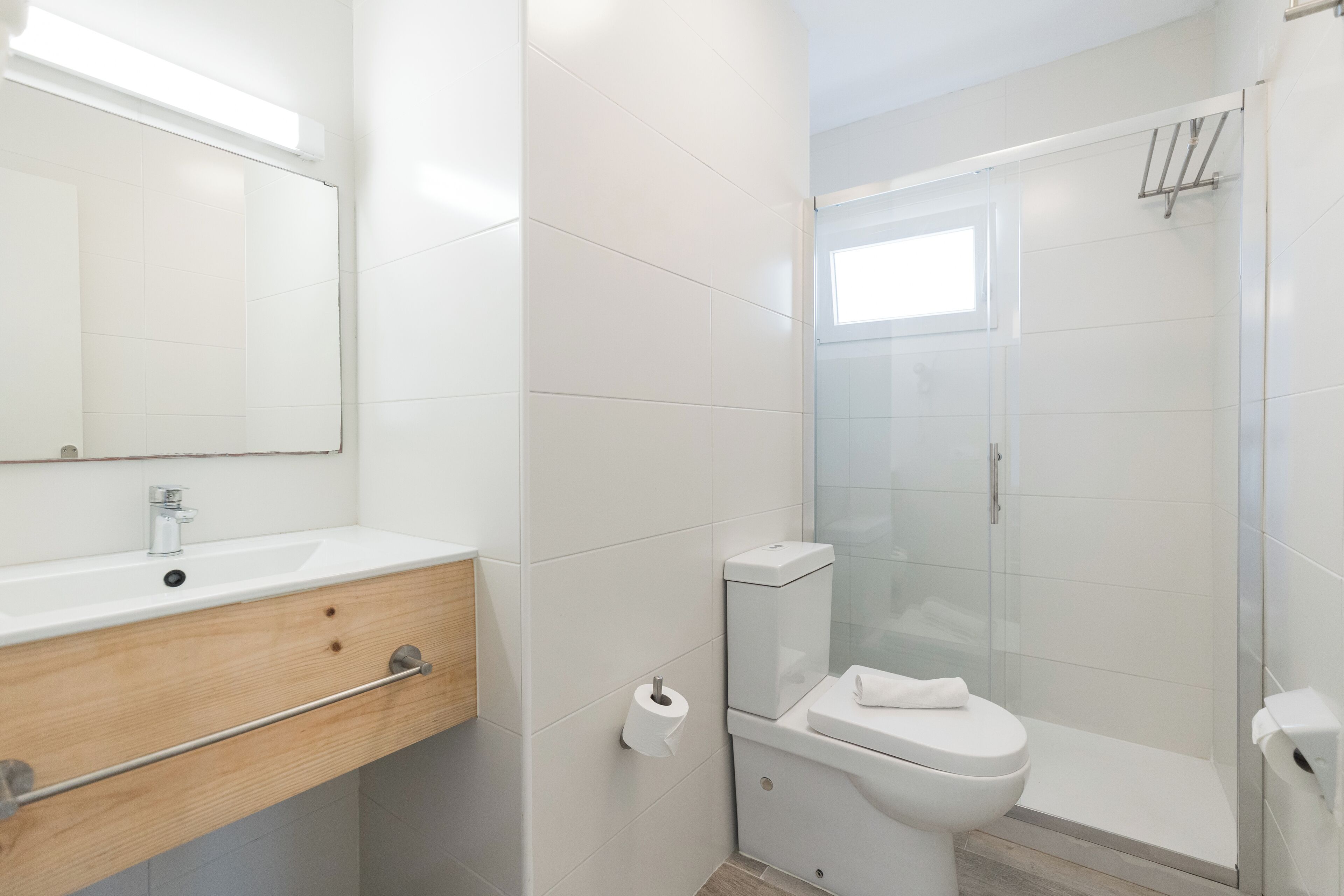 A modern bathroom with a sink, toilet, and glass-enclosed shower.