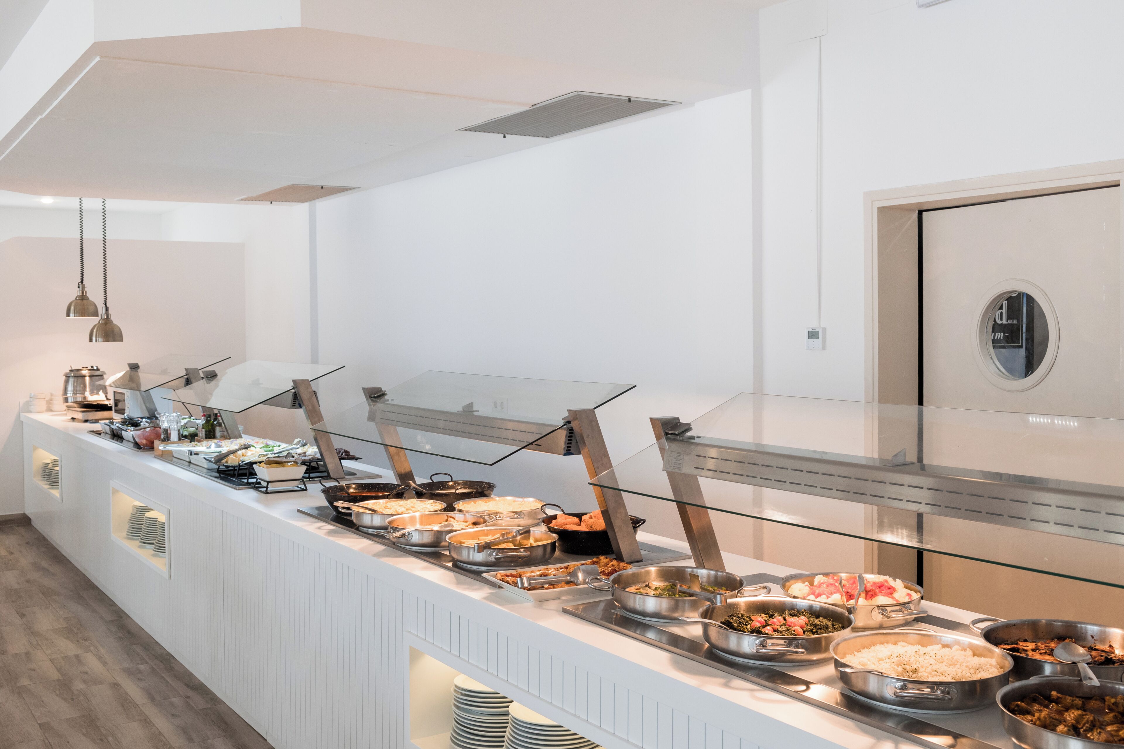 Un buffet proposant une variété de plats, une cloison en verre et un design moderne.