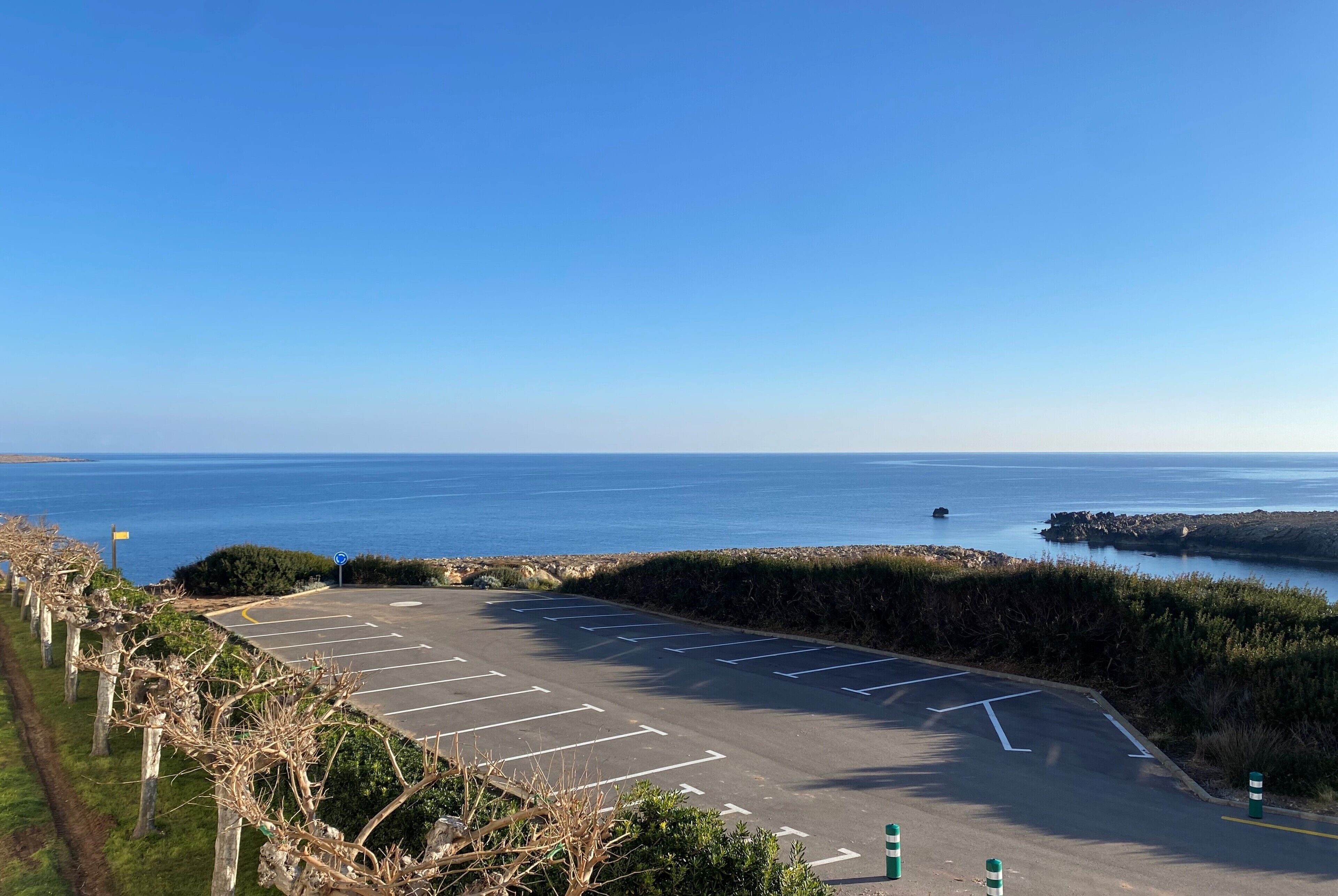 Un estacionamiento con espacios delimitados y vista al mar.