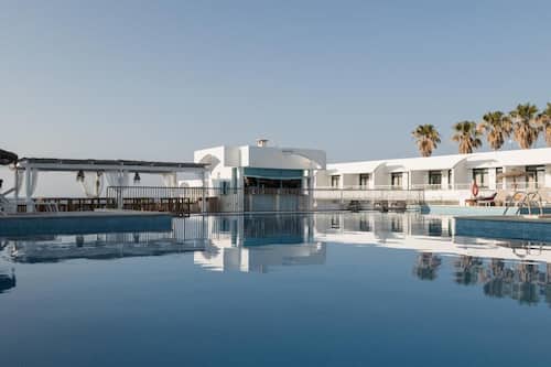 Una piscina al aire libre, sombrillas, tumbonas