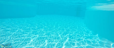 Una piscina al aire libre, tumbonas