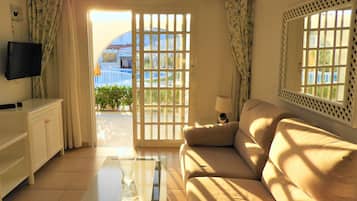 Bungalow, 1 cama Queen size, vista a la alberca | Sala de estar | Televisión de pantalla plana de 21 pulgadas con canales vía satélite