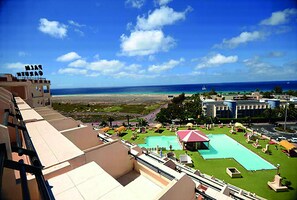 A resort with a pool area, a beach view, and a sign reading "MALIBU BEACH". - Palm Garden Apartments (Pajara)