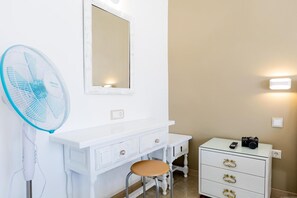 A white vanity with a mirror, a fan, a stool, and a small table with a camera. - Las Floritas (Arona)