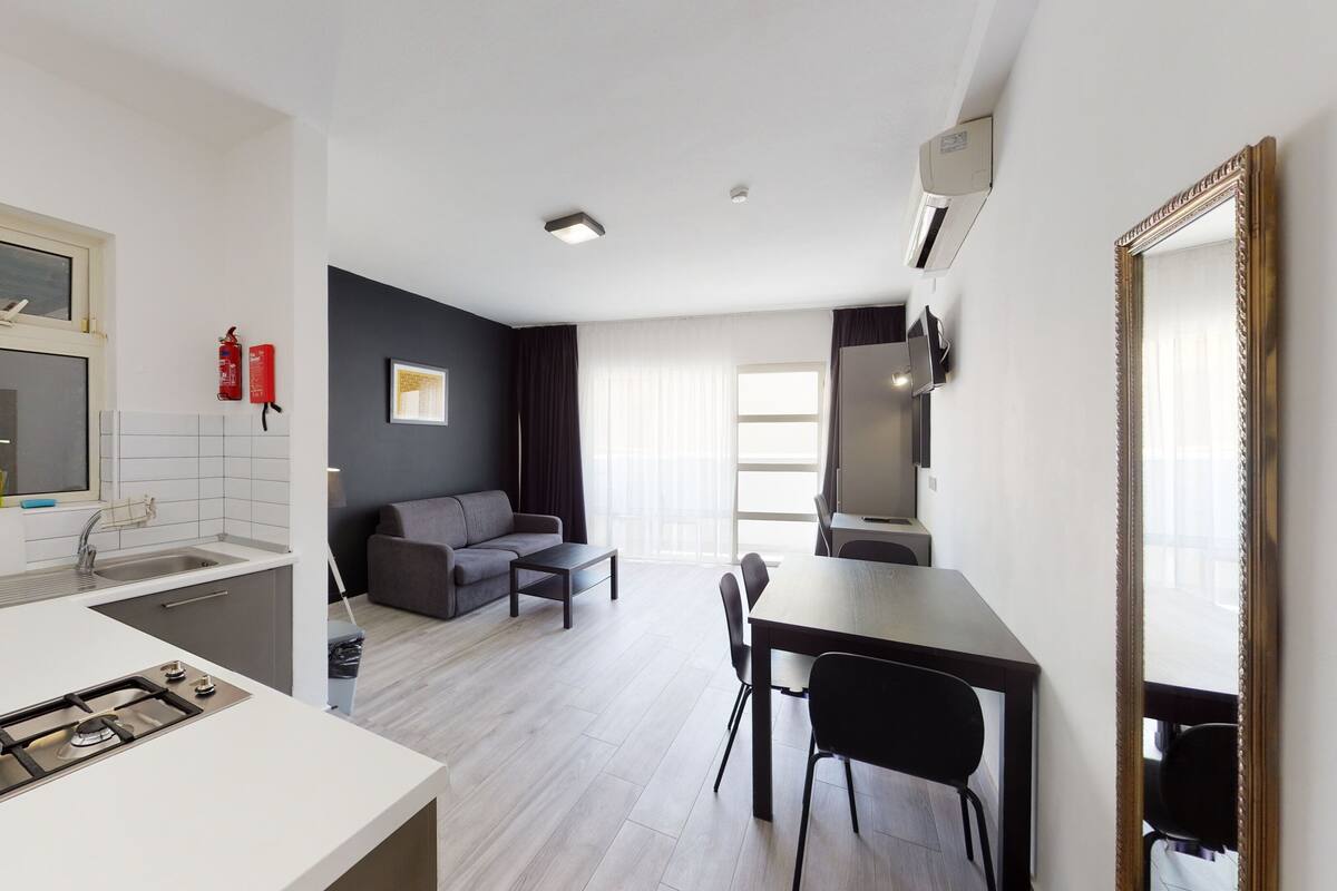 A compact living space with a kitchenette, a dining area, and a seating area.