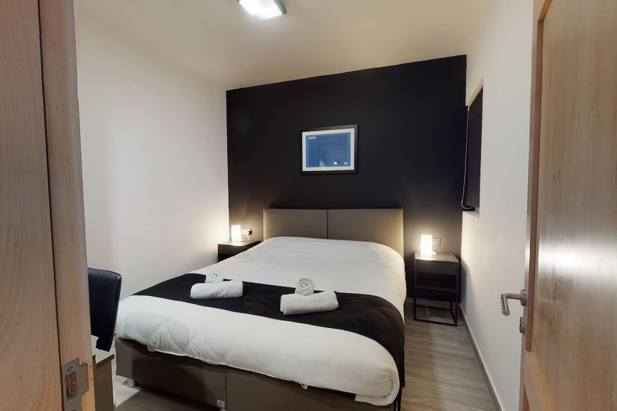 Een minibar, een strijkplank/strijkijzer, beddengoed