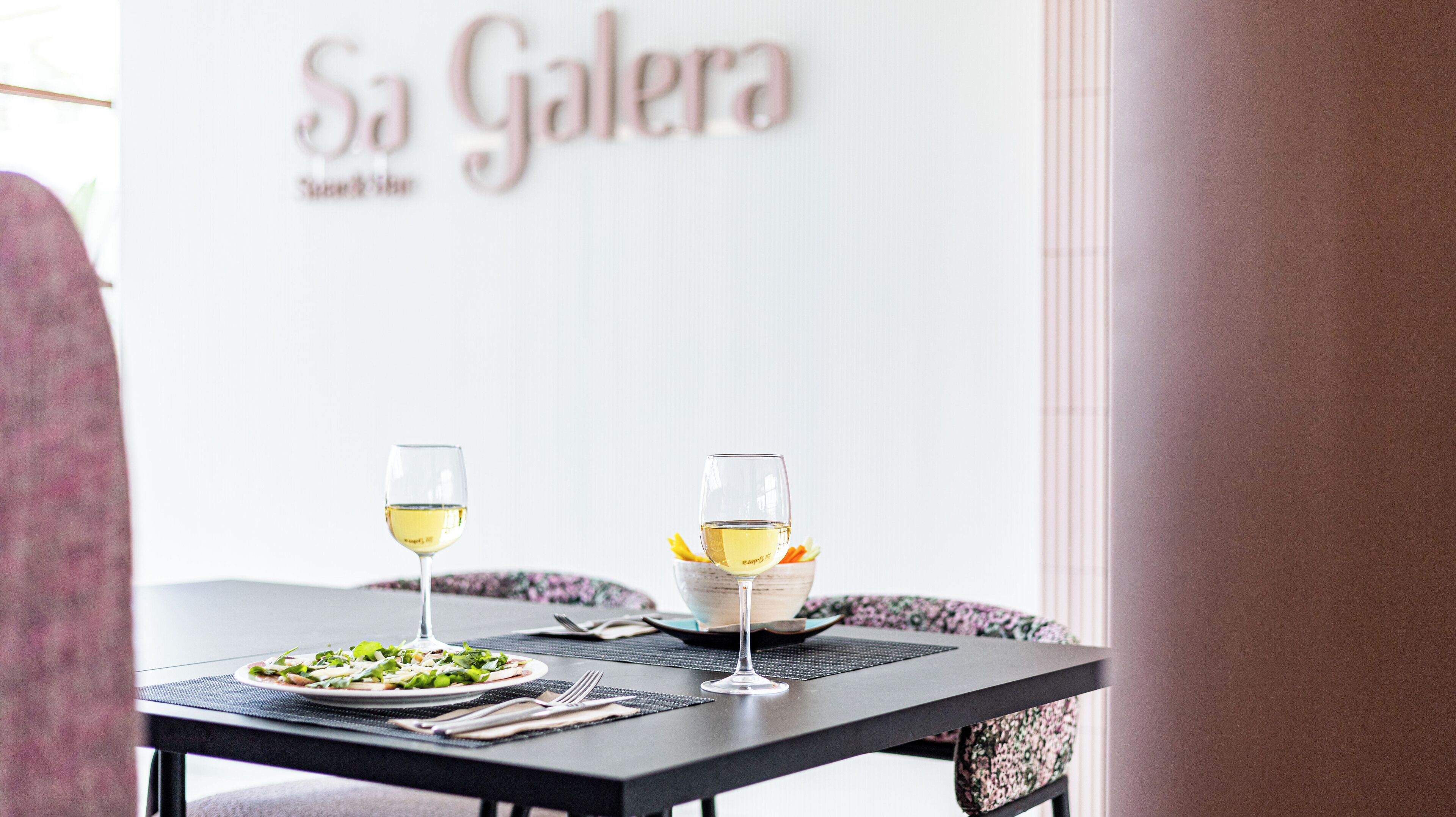 Un tavolo da pranzo con due bicchieri di vino e un piatto di cibo.