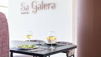 Un tavolo da pranzo con due bicchieri di vino e un piatto di cibo.