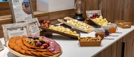 A buffet table with various food items including cheese, fruits, and nuts.