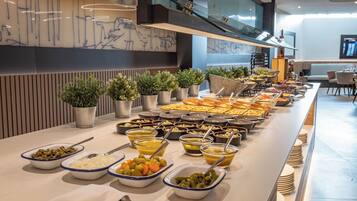 A buffet with various food items and bowls of condiments.