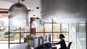 A modern kitchen with large windows, a countertop with kitchen appliances, and hanging pendant lights. - Hotel Seth Port Ciutadella (Ciutadella de Menorca)