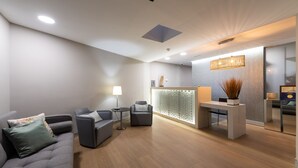 A modern reception area with a reception desk, seating area, and a decorative wall. - Apartamentos Dorotea (San Bartolomé de Tirajana)