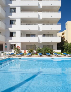A modern hotel with a swimming pool, multiple balconies, and a clear blue sky. - Green Line Bon Sol Apartamentos (Ibiza Town)