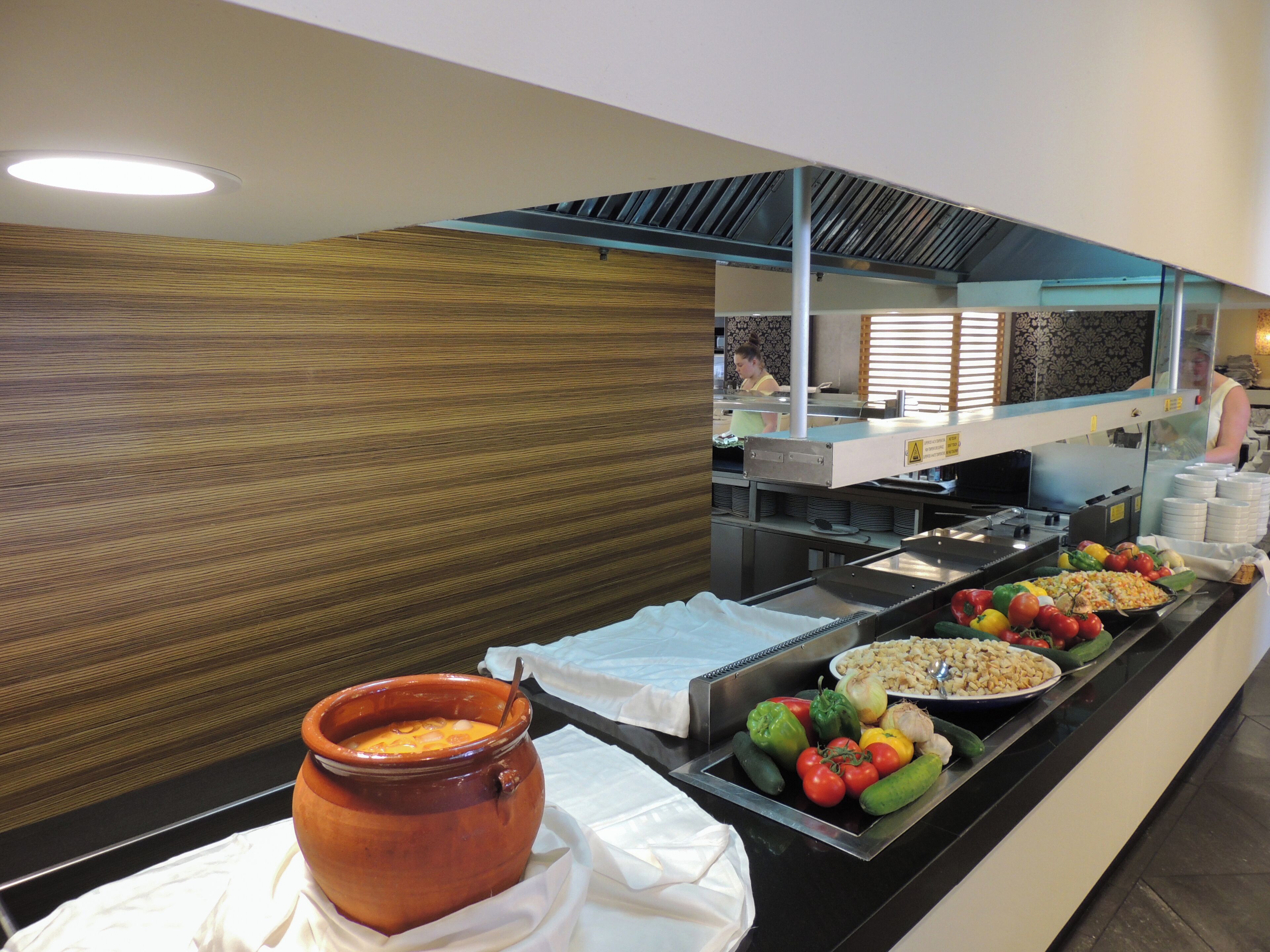 A buffet with various food items and a large pot of soup.