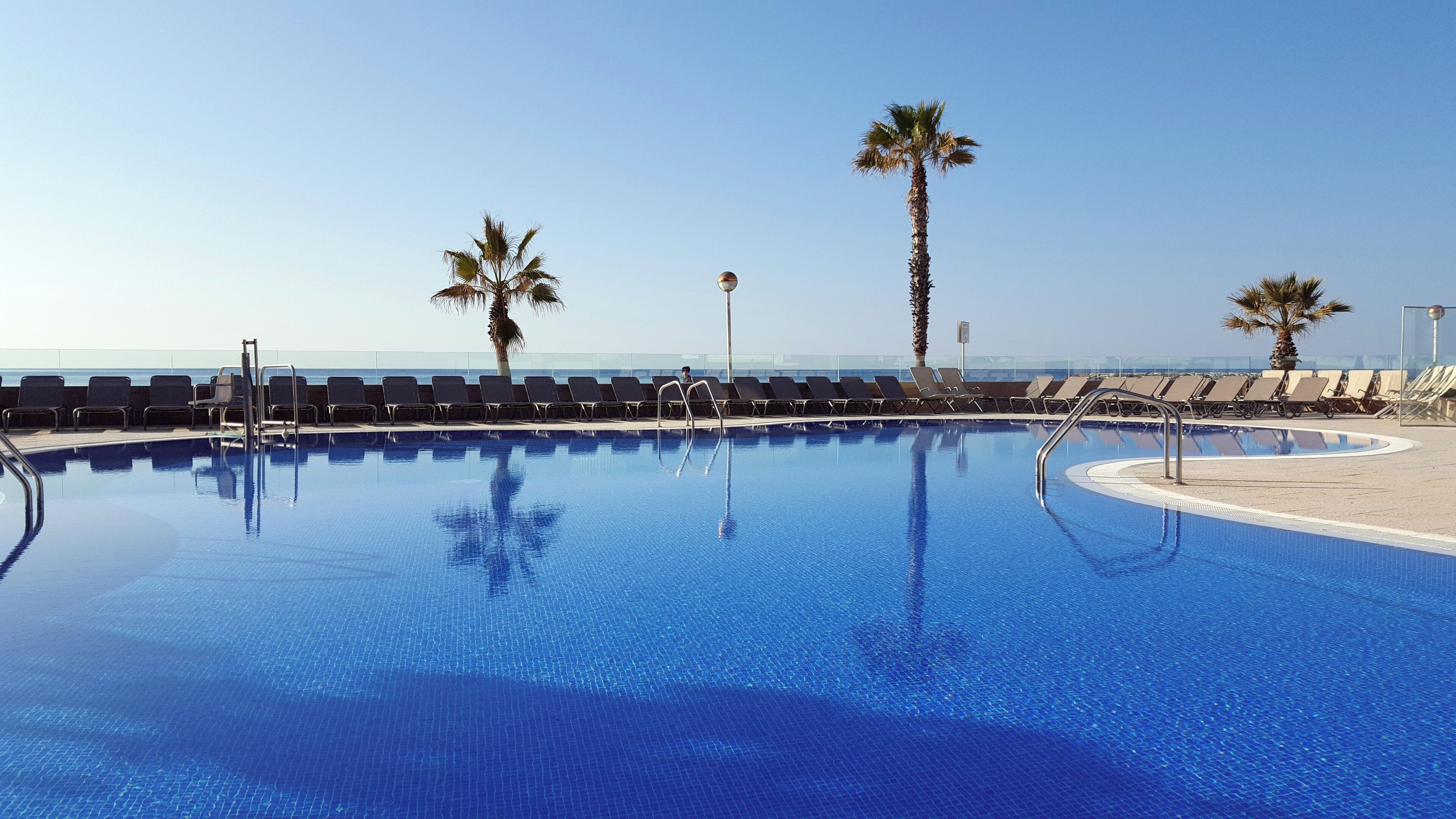 Piscine extérieure, parasols de plage, chaises longues