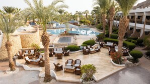 A resort pool area with lounge chairs and palm trees. - Turquoise Beach Hotel (Sharm El Sheikh)