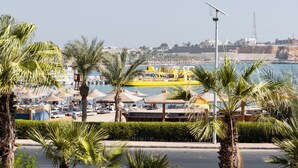 A coastal resort with sun loungers, umbrellas, and a yellow boat in the background. - Turquoise Beach Hotel (Sharm El Sheikh)