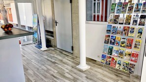 Un interior moderno con piso de madera, un pilar blanco y una pared que muestra varios folletos de viajes.