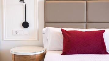 A neatly arranged bedroom with a bed, a bedside table, and a wall-mounted lamp.