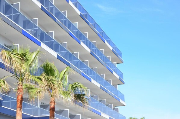 A multi-story hotel with a modern design, featuring balconies and palm trees in the foreground. - Hotel Vista Park (Santa Margalida)