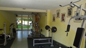 A gym with various exercise equipment, including a bench press, dumbbells, and a squat rack. - Yassen Mng Apartments (Nessebar)